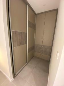 a walk in closet with glass doors and tile floors at Maison Appart, Le Cocon Brindasien, 20 min de Lyon, 66 m2 in Brindas