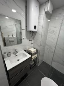 ein weißes Badezimmer mit einem Waschbecken und einem Spiegel in der Unterkunft Hello Sunshine in Zadar
