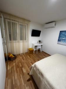 Schlafzimmer mit einem Bett, einem Tisch und einem TV in der Unterkunft Hello Sunshine in Zadar