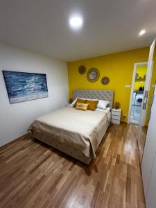 ein Schlafzimmer mit einem Bett und einer gelben Wand in der Unterkunft Hello Sunshine in Zadar