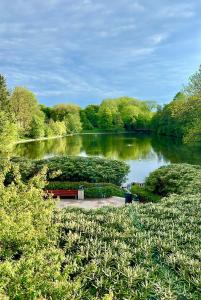 a park with a bench in front of a lake at Frogner Park Penthouse Terrace in Oslo