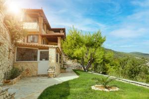a stone house with a garden and a driveway at Villas Cavo Marathia in Keri