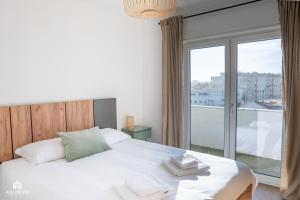 a bedroom with a bed and a large window at Casa do Parque - Santa Cruz in Santa Cruz