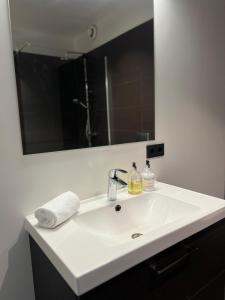 lavabo blanco con espejo grande en The Blackhouse, en Höfn