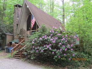 a house with a flag and flowers in front of it at Mountain Springs Chalet in Gatlinburg