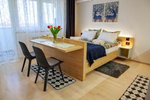 - une chambre avec un lit, une table et des chaises dans l'établissement Studio apartman D7, à Vukovar