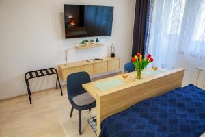 - une chambre avec un lit et un bureau avec une table dans l'établissement Studio apartman D7, à Vukovar