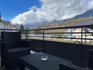 Un balcón con una silla y una mesa con vistas. en L'Evasion Alpine, en Albertville
