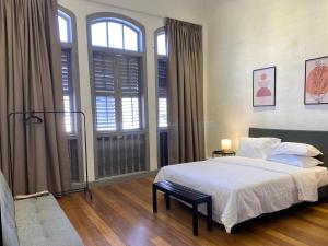 a bedroom with a bed and a large window at Aayu Melayu in George Town