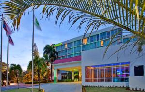マヤグエスにあるHoliday Inn Mayaguez & Tropical Casino, an IHG Hotelのヤシの木が目の前にあるホテル