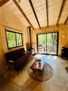 a living room with a couch and a table at Cabaña Alto del Bosque in Coñaripe