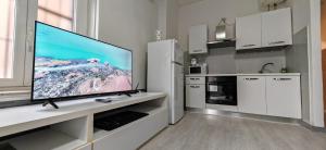 una cucina con una grande TV a schermo piatto su un bancone di La casa di Luca B&B a Lacchiarella