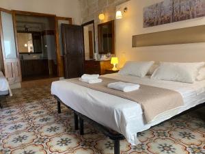 a bedroom with a large bed with two towels on it at Xemx in Qala