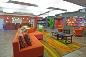 a lobby with an orange couch and a table and chairs at Holiday Inn Hotel & Suites Slidell, an IHG Hotel in Slidell