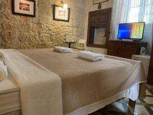 a bedroom with a bed with two towels on it at Xemx in Qala