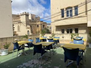 un grupo de mesas y sillas en un patio en Xemx, en Qala