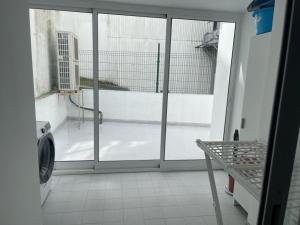 een wasmachine in een kamer met een raam bij Piso O cruceiro in O Grove
