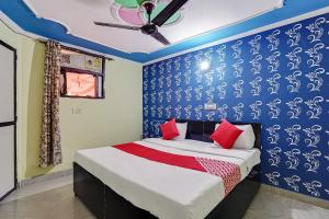 sypialnia z łóżkiem z niebieską ścianą w obiekcie Flagship Baba Guest House w mieście Indirapuram
