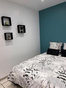 een slaapkamer met een bed en foto's aan de muur bij Maisonnette Cosy in La Ferté-Milon
