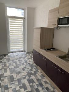a kitchen with brown cabinets and a tile floor at Am Bahnhof in Zwickau