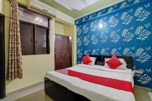 sypialnia z łóżkiem z czerwonymi poduszkami w obiekcie Flagship Baba Guest House w mieście Indirapuram