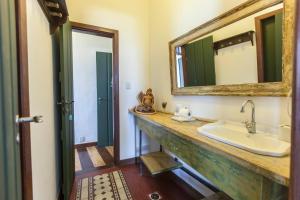 uma casa de banho com um lavatório e um espelho em Pousada Solar dos Deuses em Salvador