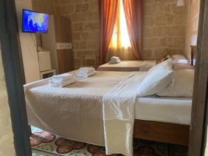a bedroom with two beds and a television in it at Xemx in Qala