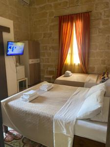 a hotel room with two beds and a window at Xemx in Qala