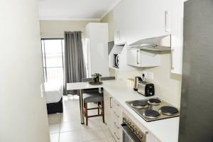 a white kitchen with a stove and a sink at Cozy Hidden gem in Midrand in Midrand