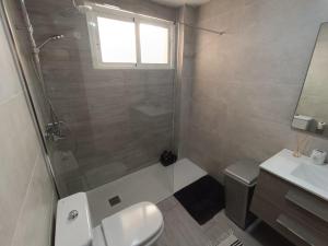 y baño con ducha, aseo y lavamanos. en Apartamento luymar, en Torre de Benagalbón