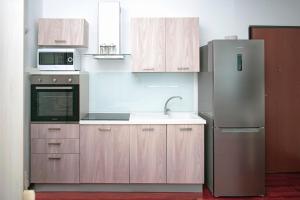 a kitchen with wooden cabinets and a stainless steel refrigerator at Il Gabbiano Napoli in Naples