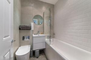een badkamer met een toilet, een wastafel en een bad bij Kula London - Tower Bridge in Londen