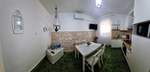 uma cozinha com uma mesa e cadeiras brancas e um balcão em Apartman Marin - Viganj em Viganj