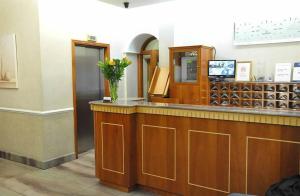 a cash counter with a vase of flowers on it at Olympic House Hotel in London