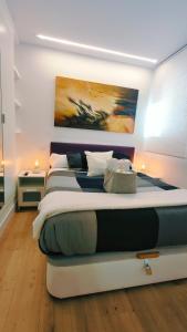 a bedroom with a large bed with a painting on the wall at Nuevo Hola Madrid BIS in Madrid