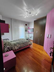 a bedroom with a zebra print bed and a pink closet at B&B Rossella in Montoro Inferiore