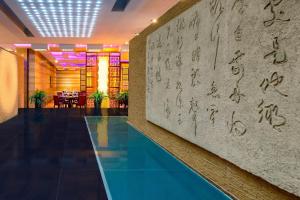 a lobby with a pool and a wall with writing on it at The Westin Beijing Chaoyang in Beijing