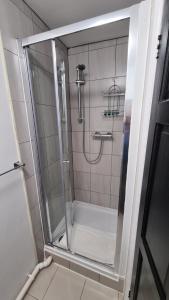 een douche met een glazen deur in de badkamer bij Moorfield House in Banbury