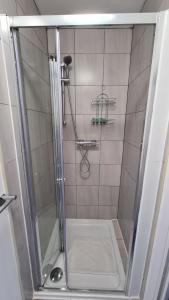 een douche met een glazen deur in de badkamer bij Moorfield House in Banbury