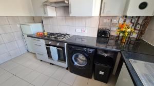 uma cozinha com uma máquina de lavar roupa e uma máquina de lavar roupa em Moorfield House em Banbury