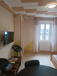 a living room with a couch and a table and a tv at Appartement 2 pièces in Le Mont-Dore