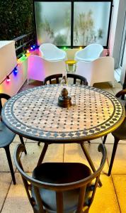 - une table et des chaises sur une terrasse éclairée dans l'établissement Appartement proche centre parking & terrasse, à Besançon