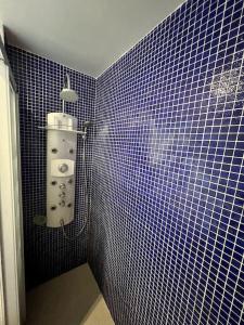 baño con pared de azulejos azules y lavamanos en Appartement lumineux Père Lachaise, en París
