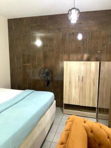 um quarto com uma cama e uma parede de madeira em OD-V!CK'S LUXE, Wuse Zone 4, Swimming Pool, Gym, WiFi, 24hr power, security, Dstv em Abuja