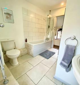 a bathroom with a toilet and a tub and a sink at Luxury Cottage Dog friendly with Hot Tub in Fairford +52 photos