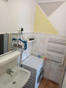 Un baño con lavadora y lavabo. en le Mont dore Centre ville appartement, en Le Mont-Dore 5 fotos más