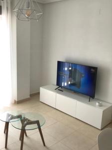 una sala de estar con TV de pantalla plana en un armario blanco en Residence Angelina, en San Miguel de Salinas