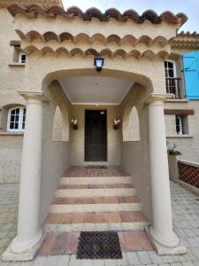 uma entrada para uma casa com colunas e uma porta em Rayol Villa Saphir em Rayol-Canadel-sur-Mer