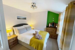 um quarto com uma cama com um cobertor amarelo em A charming cottage set in Bridgetown Totnes. em Dean