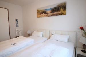 a bedroom with two beds and a picture on the wall at Kranich in Zingst